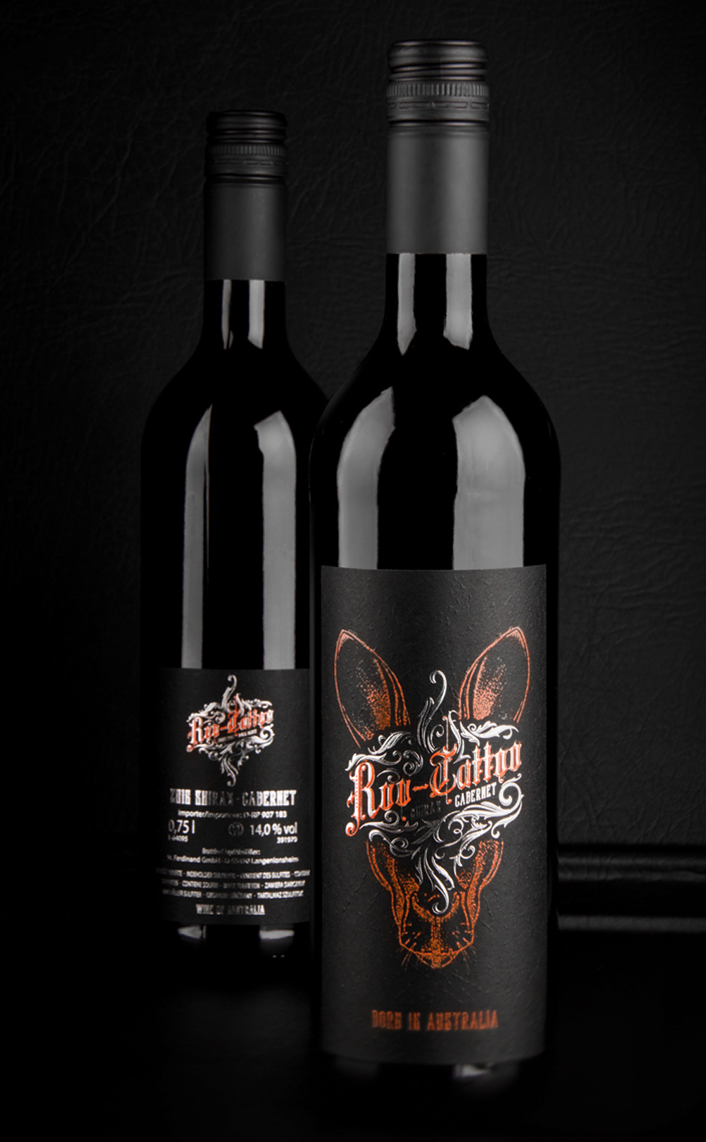 Product shot of two wine bottles standing next to each other in front of a black background. One further front showing the frontlabel and another more in the back presenting the back label.